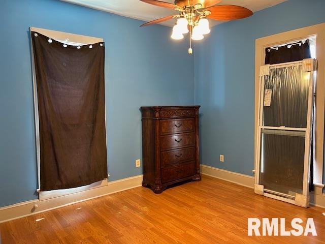 unfurnished bedroom featuring a ceiling fan, baseboards, and wood finished floors