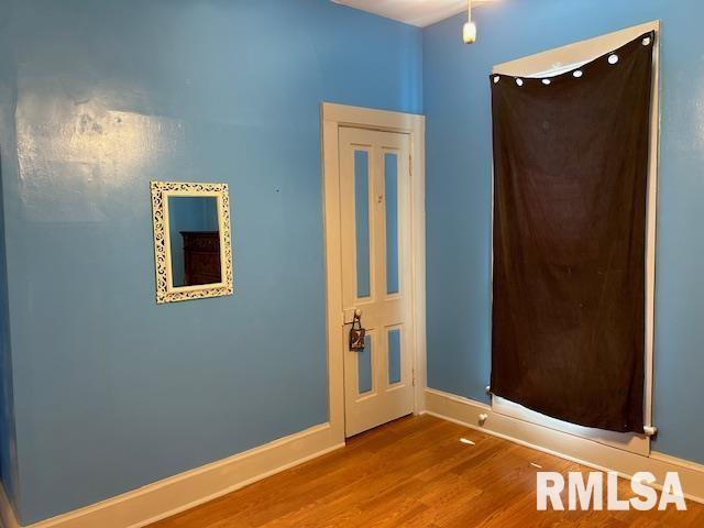 empty room with wood finished floors and baseboards