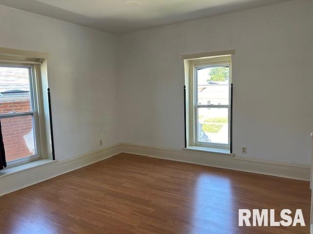 empty room featuring baseboards and wood finished floors