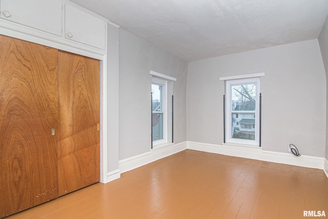 unfurnished bedroom featuring a closet, baseboards, and wood finished floors