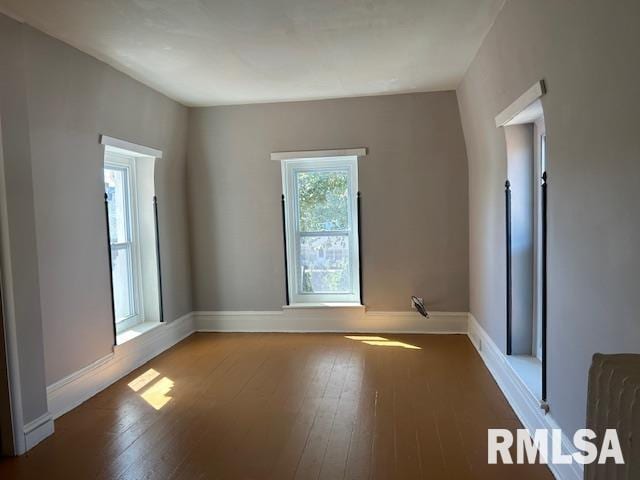 unfurnished room featuring baseboards and hardwood / wood-style floors