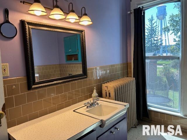512 Broad St, Sabula, IA 52070 - bathroom featuring vanity, tile walls, and radiator
