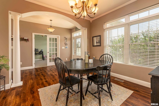 dining room with a chandelier, ornamental molding, dark wood-type flooring, and ornate columns