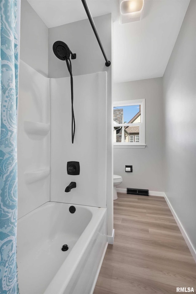 bathroom featuring toilet, wood-type flooring, and shower / tub combo with curtain