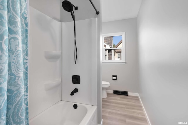 bathroom featuring hardwood / wood-style floors, toilet, and shower / tub combo with curtain