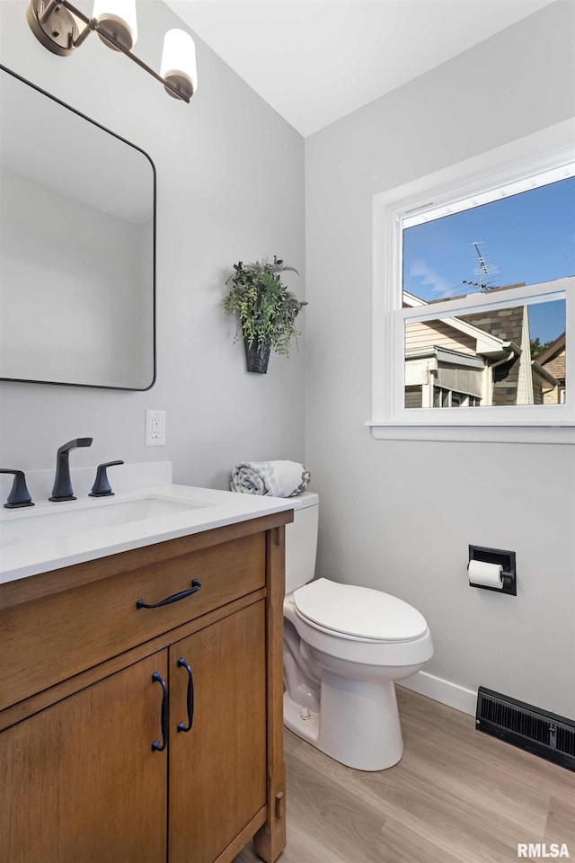 bathroom with vanity, toilet, and wood-type flooring