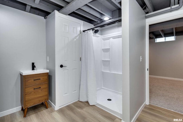 interior space featuring vanity, a shower with curtain, and hardwood / wood-style flooring