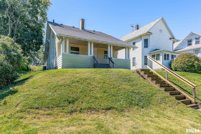 view of front of house featuring central AC unit and a front yard