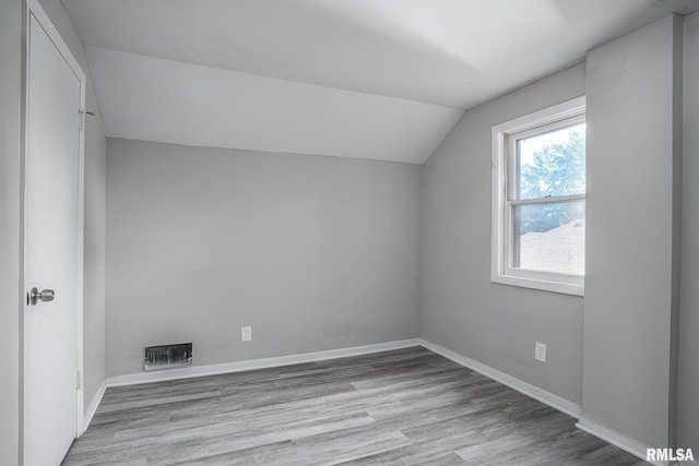 bonus room with lofted ceiling and light hardwood / wood-style floors