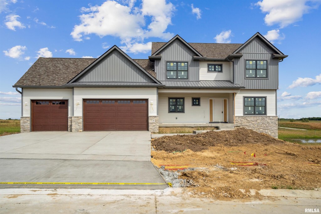 view of front of property featuring a shingled roof, stone siding, a garage, board and batten siding, and concrete driveway