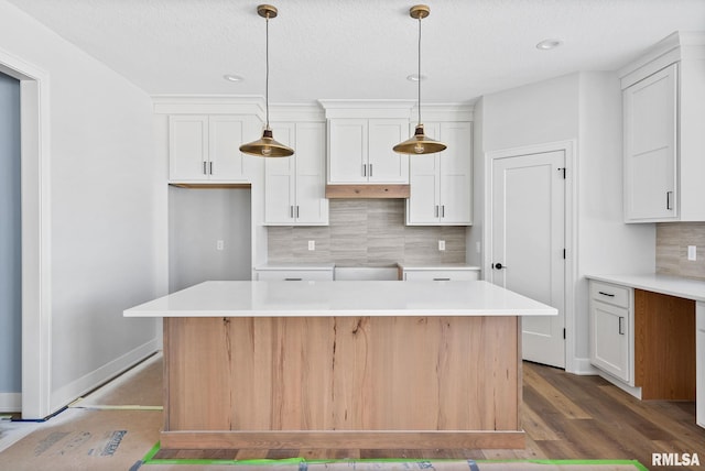 kitchen featuring decorative backsplash, white cabinetry, pendant lighting, and a center island