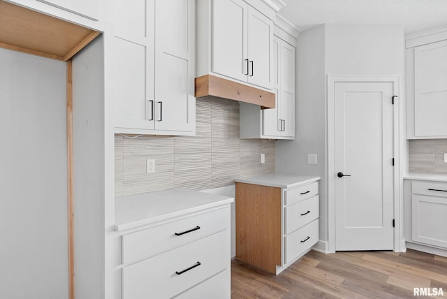 kitchen featuring light hardwood / wood-style flooring, tasteful backsplash, and white cabinets