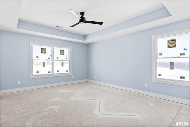 empty room with a tray ceiling and ceiling fan