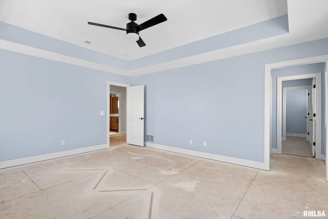 empty room with a raised ceiling and ceiling fan