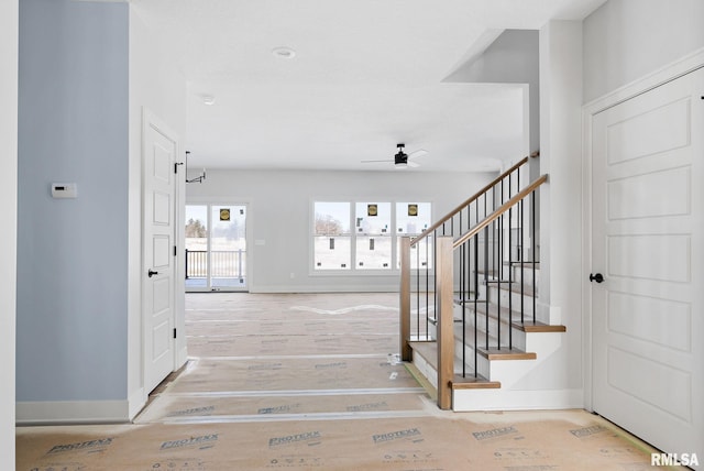 stairs featuring ceiling fan and wood-type flooring