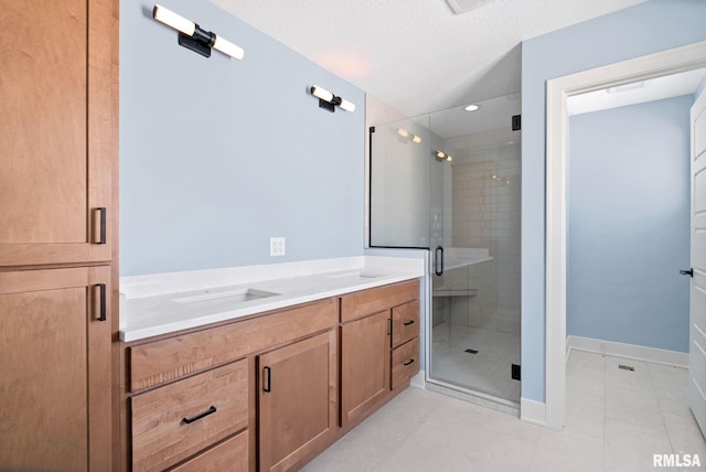 bathroom featuring vanity, a textured ceiling, and walk in shower