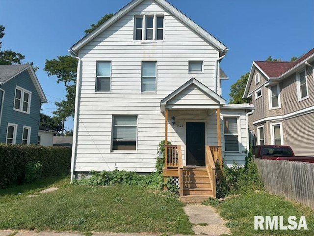 view of front facade featuring a front yard and fence