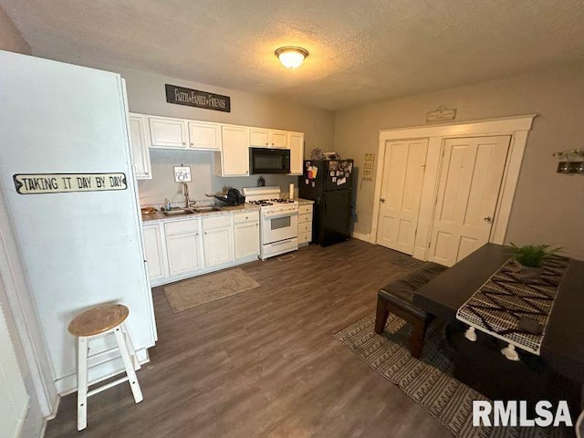 kitchen featuring black appliances, a sink, a textured ceiling, dark wood-style floors, and white cabinets