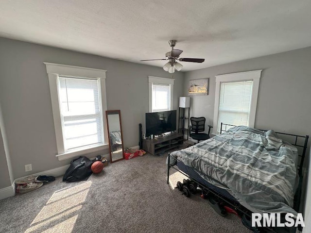 bedroom with ceiling fan, a textured ceiling, baseboards, and carpet