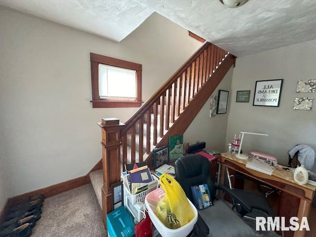 staircase with carpet, baseboards, and a textured ceiling