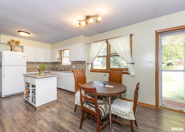 kitchen featuring dark hardwood / wood-style floors, a center island, white cabinets, and white fridge