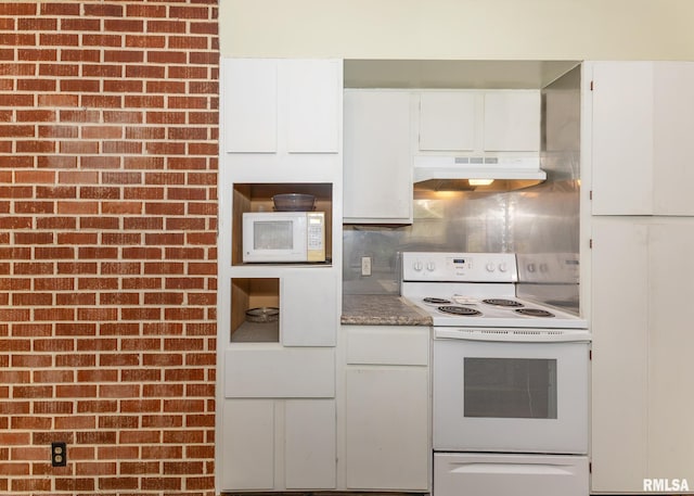 kitchen with brick wall, white appliances, white cabinets, and decorative backsplash