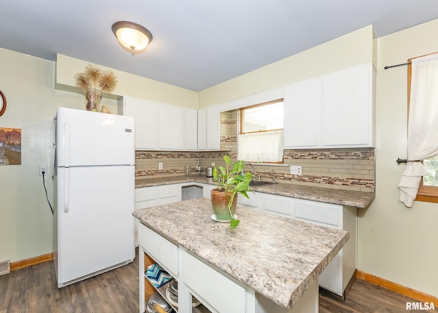 kitchen featuring dark hardwood / wood-style flooring, a kitchen island, white cabinets, and white fridge