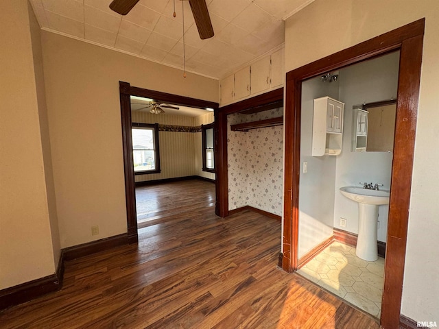 hallway with crown molding, dark wood-type flooring, and sink