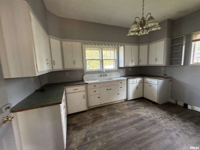 kitchen with white cabinets, dark hardwood / wood-style flooring, a chandelier, and sink