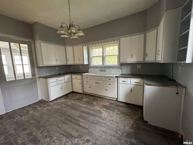 kitchen featuring white cabinetry, decorative light fixtures, an inviting chandelier, and sink