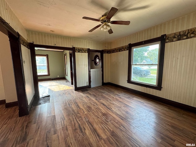 empty room featuring dark wood-type flooring and ceiling fan