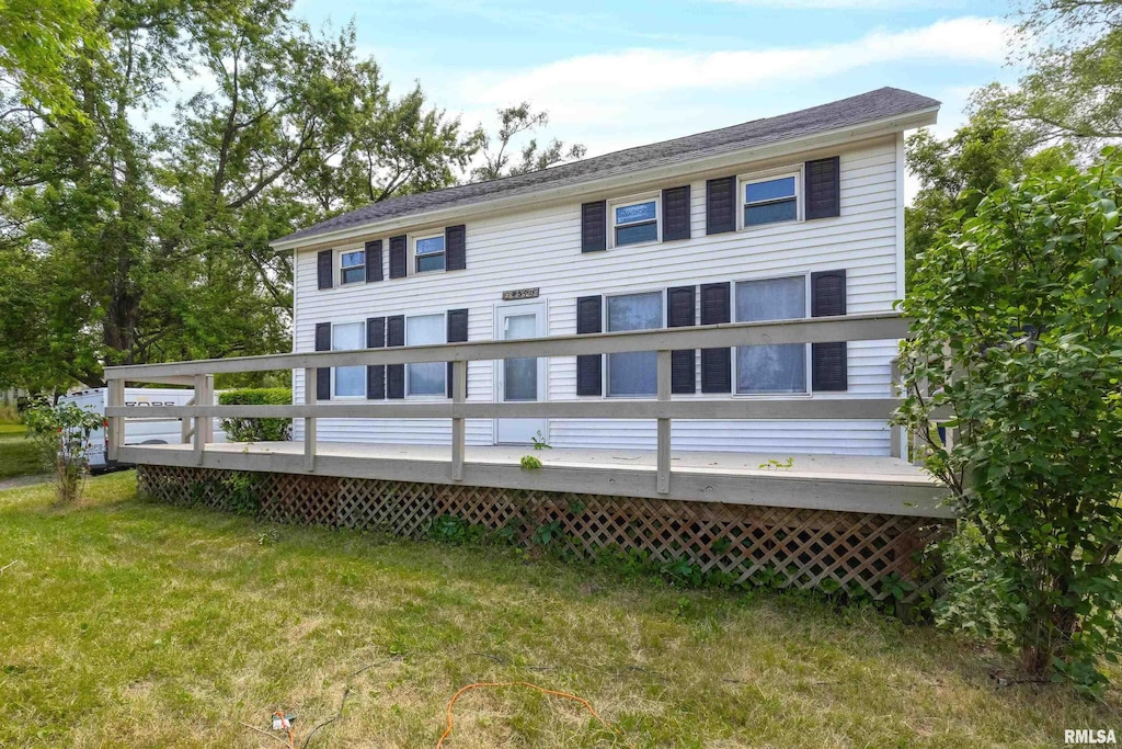 rear view of house featuring a yard and a deck