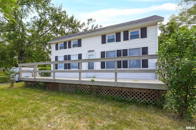 rear view of house featuring a yard and a deck