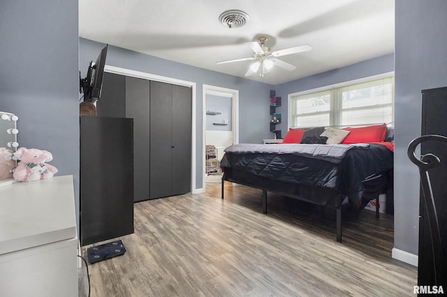 bedroom with a closet, ceiling fan, and wood-type flooring