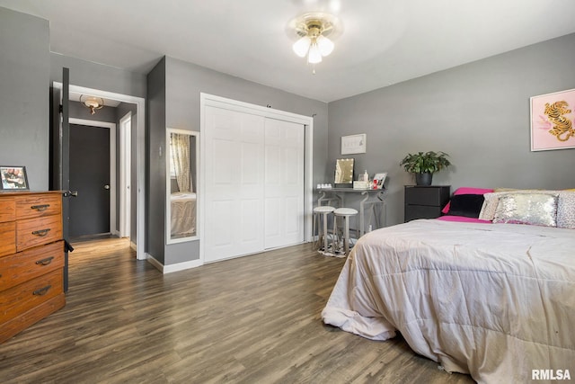 bedroom featuring dark wood-type flooring, ceiling fan, and a closet