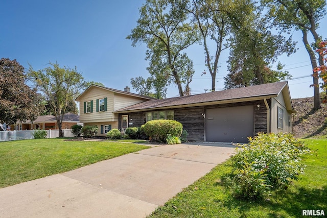 split level home with a front lawn and a garage