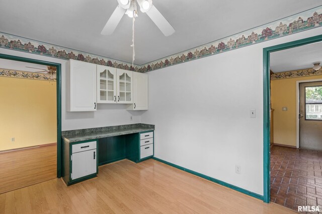 kitchen featuring white cabinets, built in desk, ceiling fan, and light hardwood / wood-style floors