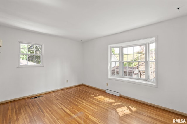 spare room featuring light wood-type flooring and baseboard heating