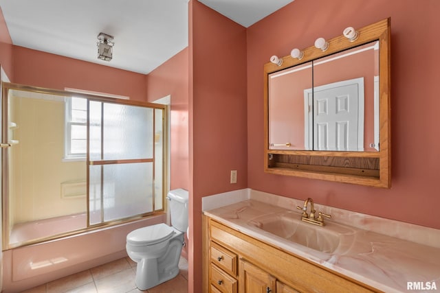 full bathroom featuring tile patterned floors, toilet, bath / shower combo with glass door, and vanity