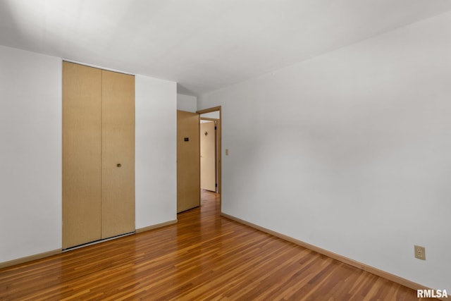 unfurnished bedroom featuring a closet and hardwood / wood-style floors