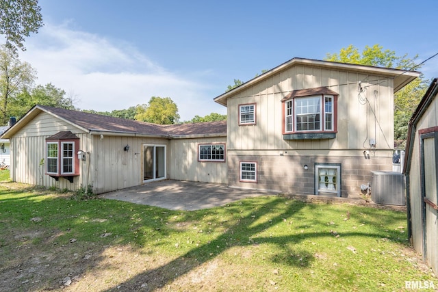 rear view of property featuring cooling unit, a lawn, and a patio