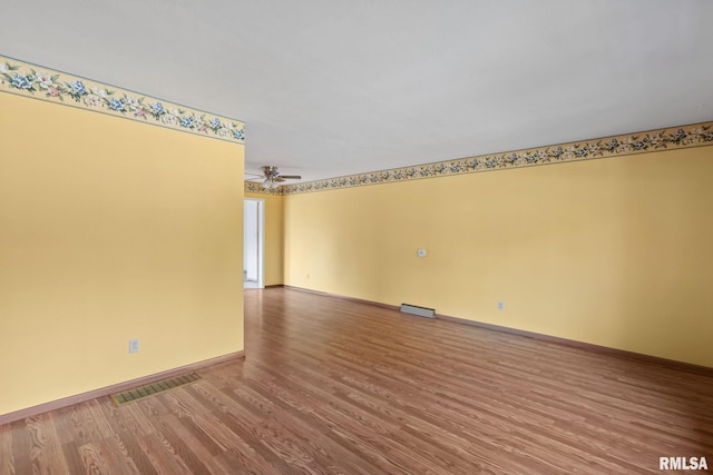 empty room with hardwood / wood-style flooring and ceiling fan