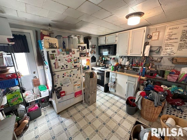 kitchen featuring sink, white appliances, and white cabinetry