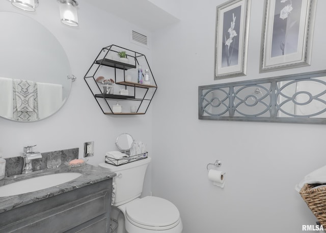 bathroom featuring vanity, toilet, and visible vents