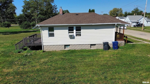 view of side of property featuring a wooden deck and a yard