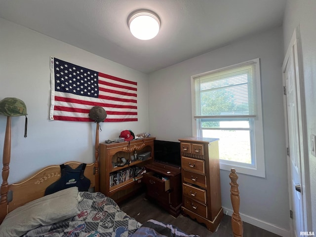 bedroom with dark wood-style floors and baseboards