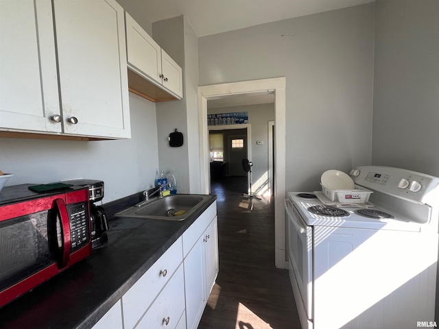 kitchen with dark wood finished floors, dark countertops, washer / clothes dryer, white cabinets, and a sink