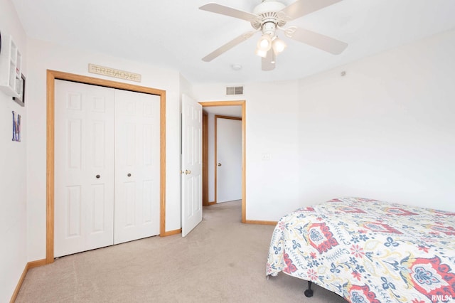 bedroom with ceiling fan, a closet, and light carpet