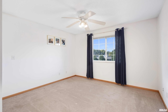 empty room with ceiling fan and light colored carpet