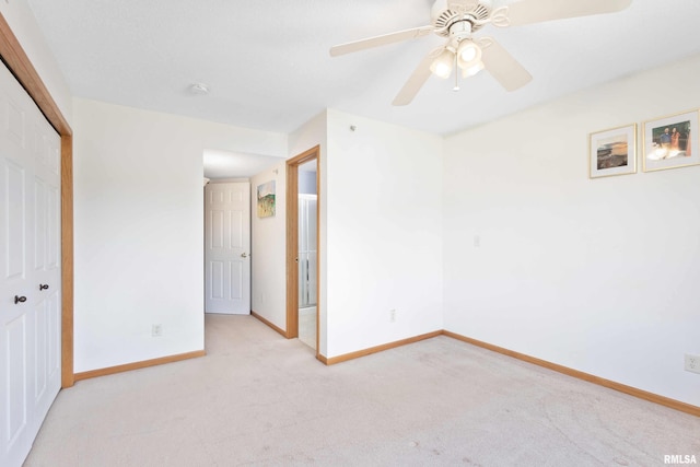 unfurnished bedroom featuring light carpet, a closet, and ceiling fan